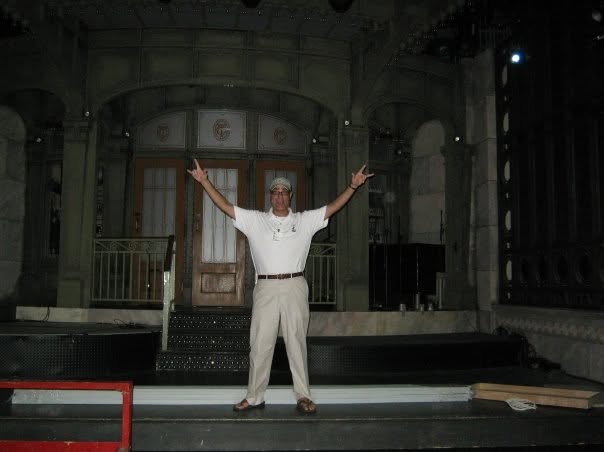 A man with his arms stretched wide on the Saturday Night Live stage set in New York City