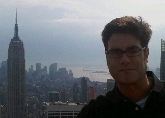 A selfie from the top of 30 Rock with the Empire State Building and the Manhattan skyline behind