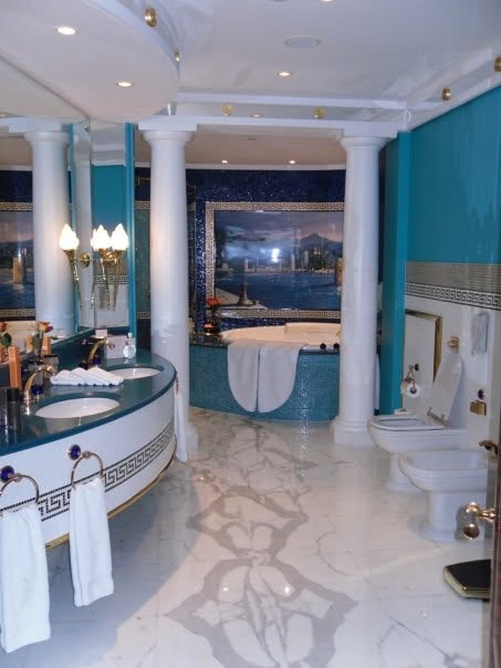 The main bathroom with turquoise mosaic walls, marble columns and a jacuzzi