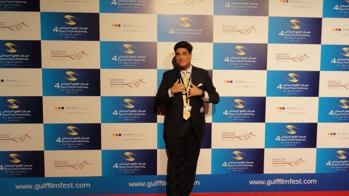 Matthew posing in front of the Gulf Film Festival backdrop