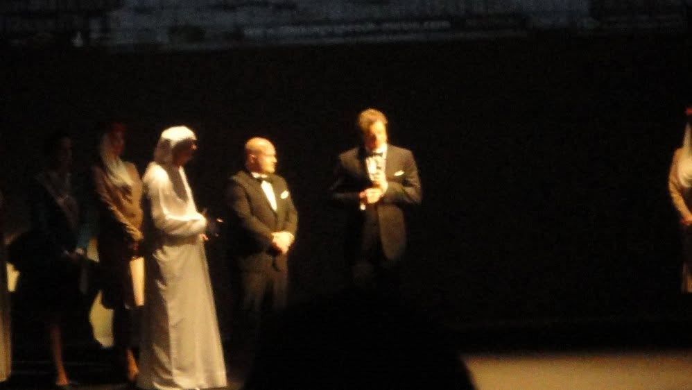 Guests in black tie and traditional dress on stage before the opening-night premiere