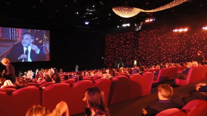 The premiere theatre with red velvet seats, a wall of lights and a big screen