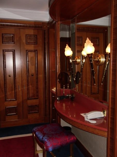 A wood-paneled dressing room with torch-shaped wall lights