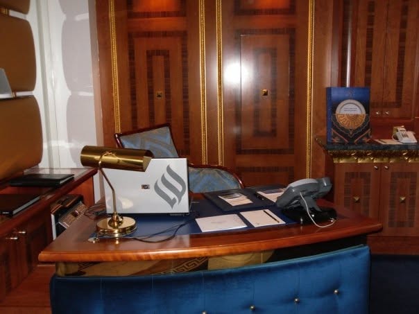 A private office with a wood desk and a gold desk lamp