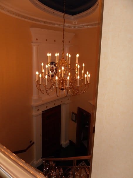 A crystal chandelier hanging in the double-height stairwell of the suite