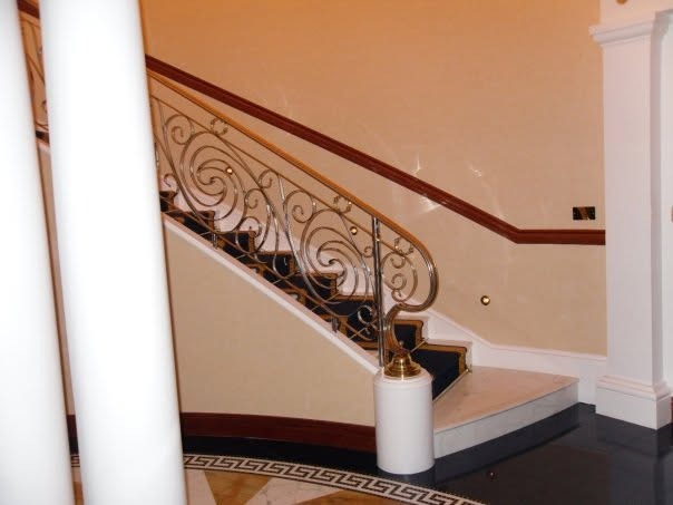 The marble staircase with a gold scroll banister